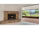 Cozy living room featuring a stone fireplace and sliding glass doors to a screened lanai with pond views at 5004 32Nd E St, Bradenton, FL 34203