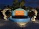 Night view of Tri-Par Estates sign featuring dolphin statues and a lighted fountain for an inviting community entrance at 5268 Boca Raton Ave, Sarasota, FL 34234