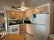 Kitchen featuring wood cabinets, white appliances, and a view into the adjoining dining area at 5268 Boca Raton Ave, Sarasota, FL 34234