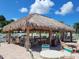 Relax poolside under a tiki hut with chairs and tables at 5268 Boca Raton Ave, Sarasota, FL 34234