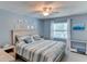 Relaxing bedroom featuring blue walls, coastal decor, ceiling fan, and queen-size bed at 5385 Avenida Del Mare, Sarasota, FL 34242