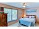 Bedroom with a large window, wooden dresser, and cozy bed at 5385 Avenida Del Mare, Sarasota, FL 34242