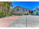 Charming two-story home with a light gray exterior, a spacious driveway, and mature tropical landscaping at 5385 Avenida Del Mare, Sarasota, FL 34242