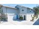 Two-story home features an attached garage, blue doors, white accents, and a well-maintained yard at 5385 Avenida Del Mare, Sarasota, FL 34242
