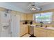 Bright kitchen featuring white refrigerator, stainless dishwasher, and window with natural sunlight at 5385 Avenida Del Mare, Sarasota, FL 34242