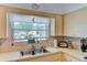 Bright kitchen featuring white countertops, stainless sink, and window with natural sunlight at 5385 Avenida Del Mare, Sarasota, FL 34242