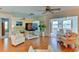 Bright living room featuring wood floors, large mirror, stylish seating, and view into sunroom at 5385 Avenida Del Mare, Sarasota, FL 34242