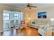 Bright living room featuring wood floors, modern ceiling fan, stylish seating, and view into sunroom at 5385 Avenida Del Mare, Sarasota, FL 34242