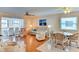 Bright living room featuring wood floors, modern ceiling fan, stylish seating, and round dining table at 5385 Avenida Del Mare, Sarasota, FL 34242
