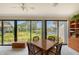 Dining area featuring sliding glass doors with a serene water view and ceiling fan at 6096 Wilshire Blvd # 9, Sarasota, FL 34238