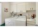 Functional laundry room equipped with a washer, dryer, and ample cabinet storage at 6096 Wilshire Blvd # 9, Sarasota, FL 34238