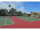 Well-maintained tennis courts surrounded by trees and blue skies at 6096 Wilshire Blvd # 9, Sarasota, FL 34238