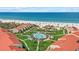 An aerial view of the community pool and pristine beach create a relaxing tropical oasis at 6204 Midnight Pass Rd # 201, Sarasota, FL 34242