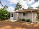 Neutral exterior with screen door, small window, and tidy landscaping, surrounded by mature trees at 635 N Jefferson Ave # 635, Sarasota, FL 34237