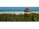 A serene beach scene showcasing a lifeguard hut, tranquil turquoise waters, and natural coastal foliage at 635 N Jefferson Ave # 635, Sarasota, FL 34237