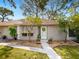 Charming single-story home featuring a well-manicured lawn and attractive landscaping under a clear blue sky at 635 N Jefferson Ave # 635, Sarasota, FL 34237