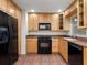 Kitchen features a black refrigerator, oven, and microwave, along with light wooden cabinetry and tile flooring at 635 N Jefferson Ave # 635, Sarasota, FL 34237