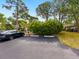 A parking area featuring one dark-colored car adjacent to a lush, green landscaped area in front of the residence at 635 N Jefferson Ave # 635, Sarasota, FL 34237