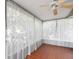 Relaxing sunroom with sheer white curtains and a ceiling fan at 635 N Jefferson Ave # 635, Sarasota, FL 34237