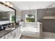Beautiful bathroom with a soaking tub, walk-in shower, granite countertop, and an elegant light fixture at 6356 Mighty Eagle Way, Sarasota, FL 34241