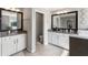 Dual sink bathroom with granite countertops, tile flooring, large mirrors, and a separate toilet room at 6356 Mighty Eagle Way, Sarasota, FL 34241