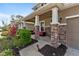 Inviting covered front porch with stone pillars, cozy seating, and colorful landscaping enhances curb appeal at 6356 Mighty Eagle Way, Sarasota, FL 34241