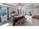 Bright primary bedroom with tray ceiling, ceiling fan, and a sitting area with many windows at 6356 Mighty Eagle Way, Sarasota, FL 34241