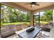 Enclosed patio area featuring a ceiling fan, table, chairs and beautiful views of the outdoor landscape at 6356 Mighty Eagle Way, Sarasota, FL 34241