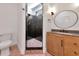 Modern bathroom showcasing a black tiled shower with a unique pink and black tiled floor, vanity and lighting at 681 Avenida De Mayo, Sarasota, FL 34242