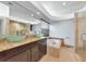 Bright bathroom featuring double sinks, granite countertops, a jacuzzi tub and a walk-in shower with a glass door at 681 Avenida De Mayo, Sarasota, FL 34242