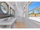 White bathroom featuring beadboard paneling, tile floors, a double vanity, and a bright window view at 681 Avenida De Mayo, Sarasota, FL 34242