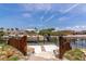 Home's dock with a boat lift, wooden fences, sandy base, and a canal view at 681 Avenida De Mayo, Sarasota, FL 34242
