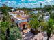 Beautiful two-story home with lush tropical landscaping, a red tile roof and brick paved driveway at 681 Avenida De Mayo, Sarasota, FL 34242