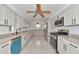 Bright kitchen with white cabinets, marble countertops, stainless steel appliances, and an island with a blue accent at 681 Avenida De Mayo, Sarasota, FL 34242