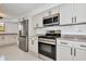Well-equipped kitchen features stainless steel appliances, white cabinetry, and marble countertops for a modern look at 681 Avenida De Mayo, Sarasota, FL 34242