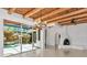 Bright living area with a wood beam ceiling and fireplace with views of the pool at 681 Avenida De Mayo, Sarasota, FL 34242