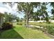 Scenic backyard view featuring a tranquil pond, lush greenery, and mature trees for added privacy at 7124 Rue De Palisades # 21, Sarasota, FL 34238