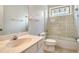 Well-lit bathroom featuring a tub with glass door, vanity, and stained glass window at 7124 Rue De Palisades # 21, Sarasota, FL 34238