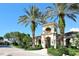 Stunning exterior of grand building entrance with a tower framed by lush palm trees at 7124 Rue De Palisades # 21, Sarasota, FL 34238