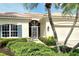 Home exterior features a lush, tropical landscape, a tile roof and an inviting walkway to the front door at 7124 Rue De Palisades # 21, Sarasota, FL 34238