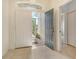 Bright foyer with tiled floor, storm door, and hallway access to the home's interior at 7124 Rue De Palisades # 21, Sarasota, FL 34238
