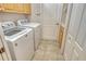 Laundry room with tile floor, cabinets, utility sink, and white front-loading washer and dryer at 7124 Rue De Palisades # 21, Sarasota, FL 34238