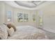 Bright main bedroom with tray ceilings featuring a ceiling fan and outdoor access to the patio at 7124 Rue De Palisades # 21, Sarasota, FL 34238