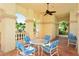 Comfortable outdoor seating area with a ceiling fan, tiled floors and views of the lush greenery at 7124 Rue De Palisades # 21, Sarasota, FL 34238