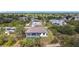High-angle shot of a modern single-Gathering home with screened pool, complemented by verdant trees and neighborhood views at 7152 Bougainvillea St, Englewood, FL 34224