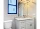 Modern bathroom with marble countertop, white cabinets, gold faucet, window, and brushed bronze pulls at 7152 Bougainvillea St, Englewood, FL 34224