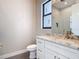 Modern bathroom featuring a white vanity with a marble countertop and a sleek, gold-colored faucet at 7152 Bougainvillea St, Englewood, FL 34224