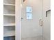 Modern bathroom featuring a glass-enclosed shower with gray patterned tile and a built-in shelving unit at 7152 Bougainvillea St, Englewood, FL 34224