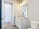 Bright bathroom with a white vanity, granite countertop, gold fixtures, and herringbone floors at 7152 Bougainvillea St, Englewood, FL 34224