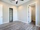 Bedroom featuring wood-look floors, ceiling fan, an open closet, and an ensuite bathroom at 7152 Bougainvillea St, Englewood, FL 34224